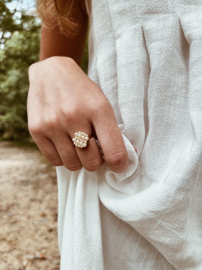 A cluster ring of small freshwater pearls worn on a hand